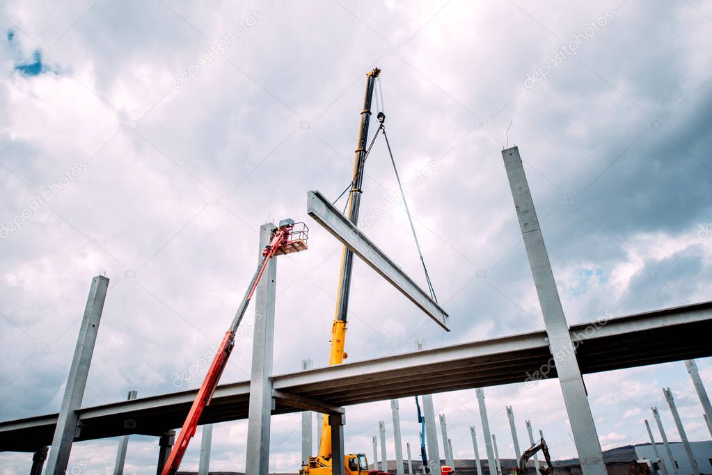 Crane lifting  concrete frameworks, shutterings and heavy prefabricated concrete components at construction site