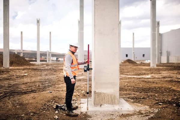 Inchiesta o ingegnere con attrezzature e strumenti di teodolite in cantiere all'aperto durante i lavori di rilevamento — Foto Stock