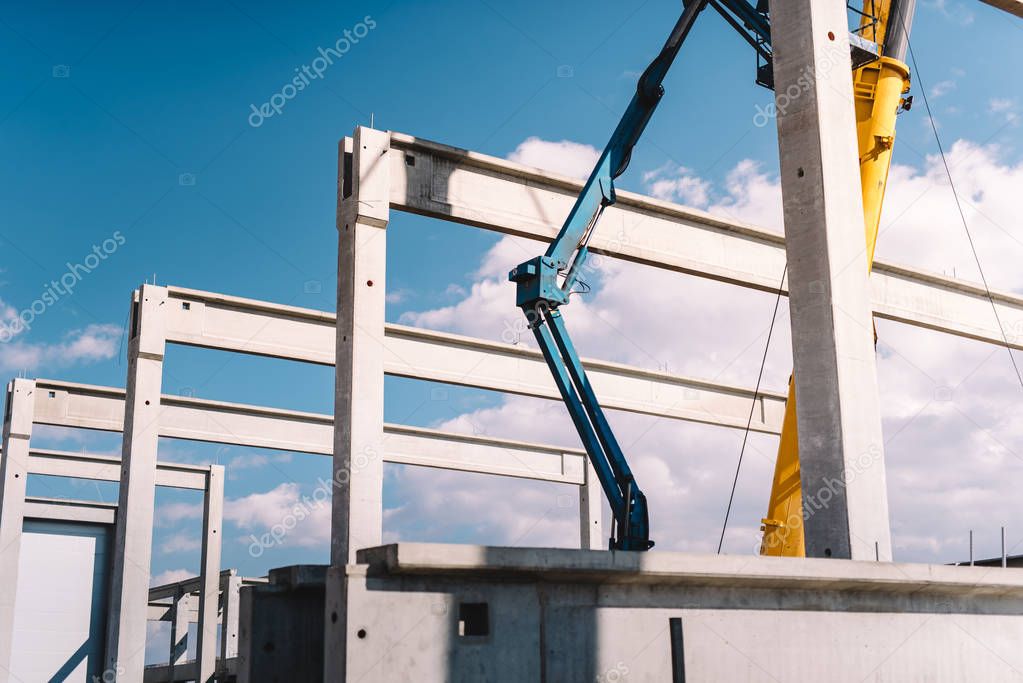 Installation of prefabricated cement pillars and beams on construction site