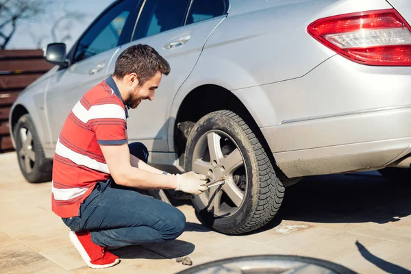 Automobilový problémy - muž chaning pneumatiky, sezónní letní pneumatiky — Stock fotografie