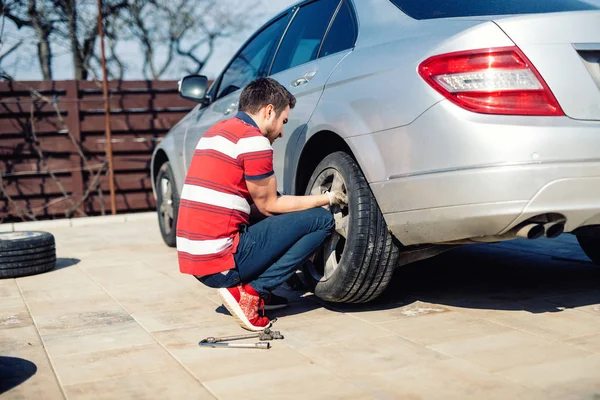 Pneuservis, pneumatiky poškozené auto nebo změna sezónních pneumatik. Změna plochý autoplášť ve dvoře. — Stock fotografie