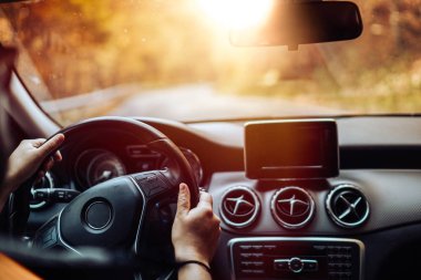 Kafkas sürücüsü günbatımında dağ yolunda modern elektrikli arabayı test ediyor.