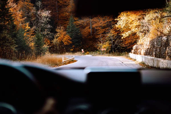 Caucasian driver holding hands on steering wheel and driving on mountain road — Stock Photo, Image