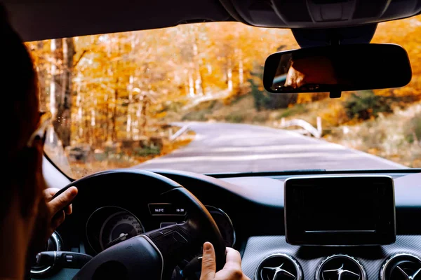 Porträt eines mittleren Erwachsenen, der mit einem Auto auf Asphaltstraße durch den Wald fährt — Stockfoto