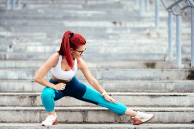 Atletik beyaz kadın esneme egzersizleri ve kalaslar yapıyor. Spor salonu spor konsepti