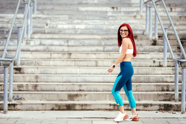 Retrato de una mujer sonriente que se ríe mientras hace ejercicio. Entrenamiento físico y concepto de estilo de vida saludable —  Fotos de Stock