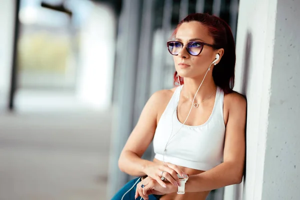 Retrato de mulher sorridente ouvindo música e treinamento com smartwatch — Fotografia de Stock