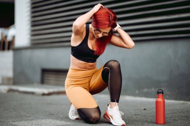 Aktif koşan kadın koşucunun yakın çekimi, ayakkabıları hazırlamak ve gülümsemek.