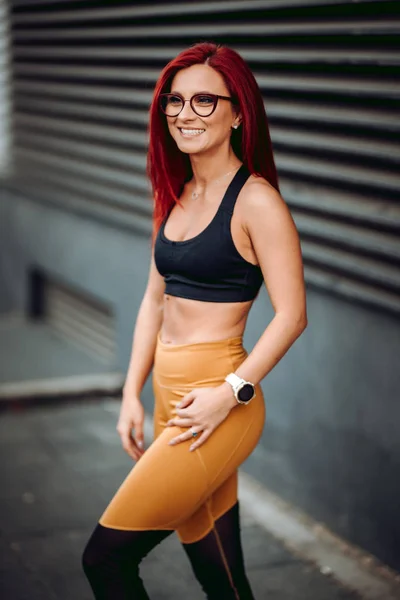 Portrait de femme sportive souriant à l'extérieur regardant loin contre un mur en métal. Concept de coureuse relaxante après l'entraînement . — Photo