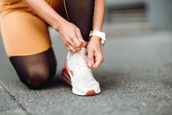 Primer plano de la corredora activa de jogging, preparando zapatos para entrenar y ejercitarse en el entrenamiento físico — Foto de Stock