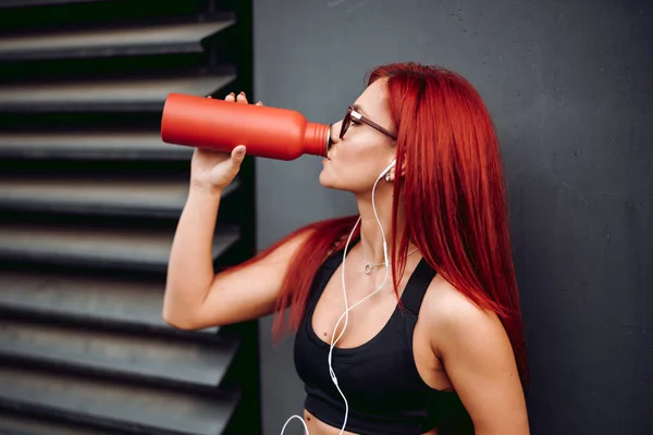 Atleta profesional bebiendo agua de una botella especial mientras corre y hace ejercicio — Foto de Stock