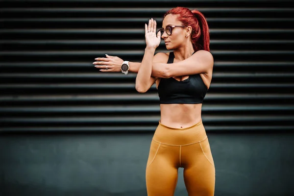 Corredor femenino estirándose, preparándose para el entrenamiento. Deportista de fitness calentándose para correr . —  Fotos de Stock