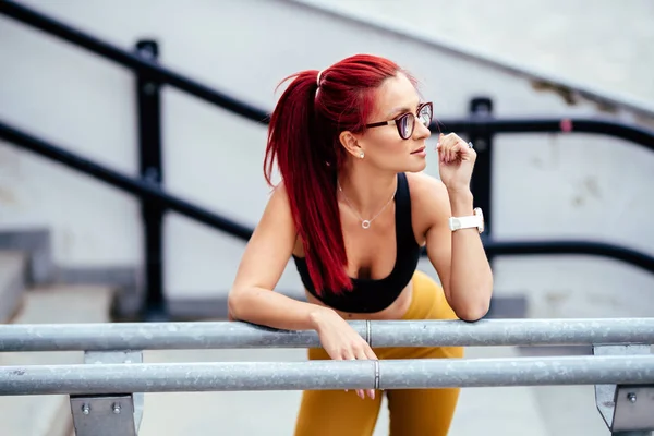 Concepto de fitness - mujer culturista sentada y sonriente en el entrenamiento de escaleras —  Fotos de Stock