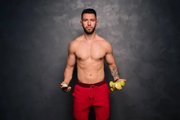 Healthy habits concept, healthy lifestyle concept with man holding dumbbells and cigarettes - shirtless man