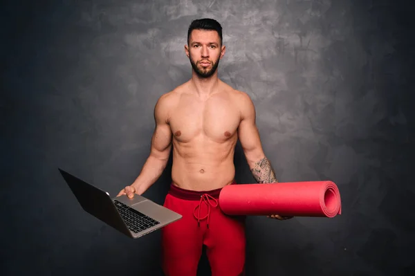 Concepto de hábitos saludables, concepto de estilo de vida saludable con el hombre sin camisa sosteniendo una computadora portátil y una esterilla de entrenamiento —  Fotos de Stock