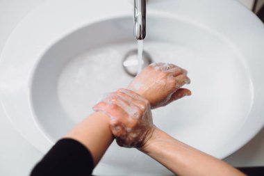 Evde ellerini fırçalayan ve yıkayan kadın detaylarını kapat. Hijyen ve vücut temizliği konsepti ayrıntıları