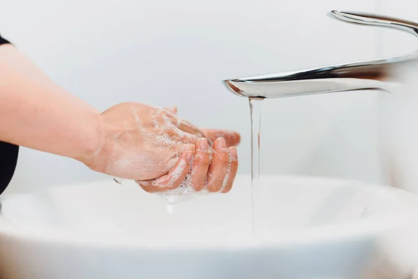 石鹸と水道水で手を洗う白人女性の詳細を閉じます — ストック写真