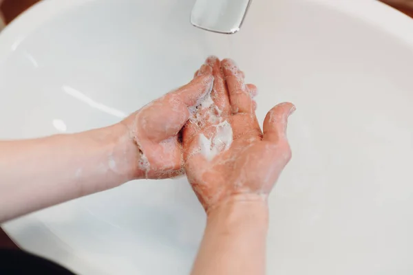 Close up details of hand soap, disinfectant and antimicrobial soap in woman hands. Hand washing
