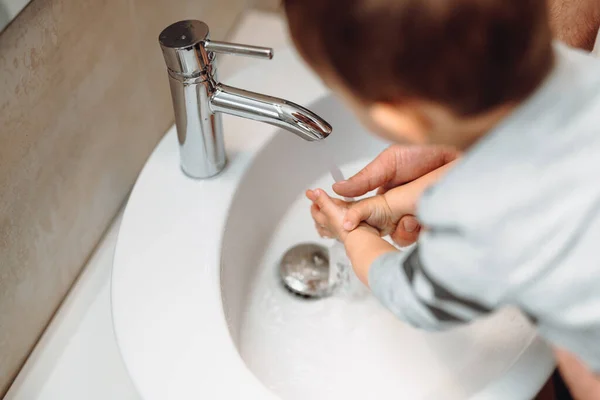 石鹸で父と子供を洗い 手を洗うために水をタップします 抗菌石鹸を使用して小さな幼児 自宅でお父さんと手を洗う — ストック写真