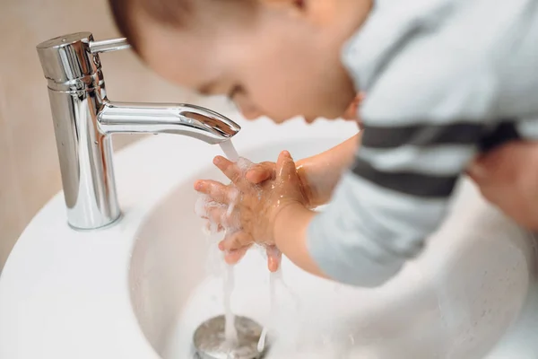 小さな子供 赤ちゃんの洗濯や石鹸ディスペンサーで手を洗浄し 水をタップしようとしています 父と息子は手を洗う — ストック写真
