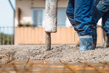İnşaat alanında çalışan beton otomatikman pompa tüpü, beton döken ve yöneten işçiler