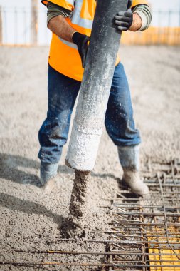 İnşaat sırasında dökülen betonun detayları. Endüstriyel detaylar, makineler ve insanlar