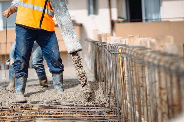 Building construction site details - building concrete slabs at house construction and pouring cement on reinforcement bars