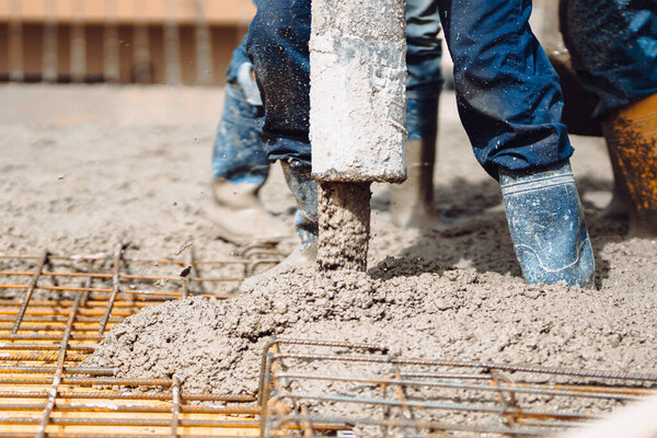 Caucasian people pouring cement using automatic pump. Construction site details, cement slabs 