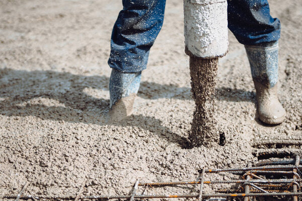 Industrial worker using concrete pipe pump for building house. Close up of industrial equipment