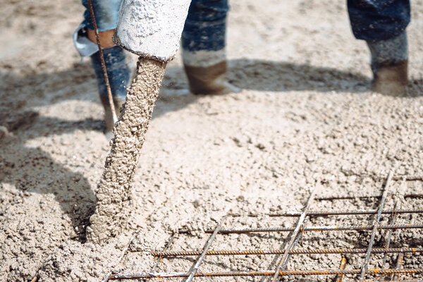 Close up details of concrete pouring during construction of house. Industrial details, machinery and people