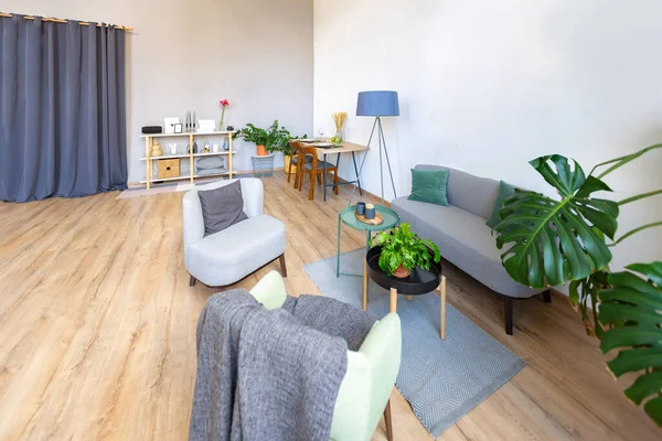 interior stylish loft, spacious apartment with large windows, parquet on the floor and light walls, modern furniture in blue Scandinavian style, free space planing