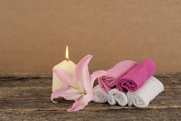 Vacker komposition med ljus, rosa Lilja blomma och spa handdukar på trä bakgrund — Stockfoto