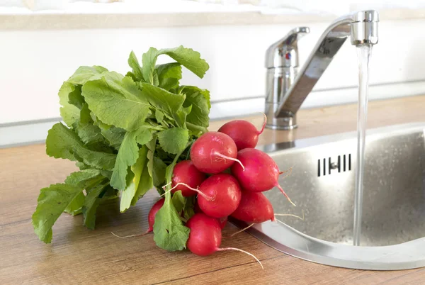 Un montón de rábano rojo lavado en la cocina — Foto de Stock