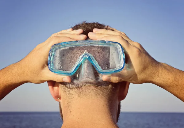 Un uomo con una maschera subacquea sta dietro — Foto Stock