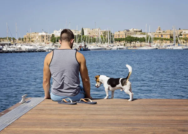 Ένας άντρας με ένα σκύλο περπάτημα στην πλωτή αποβάθρα — Φωτογραφία Αρχείου