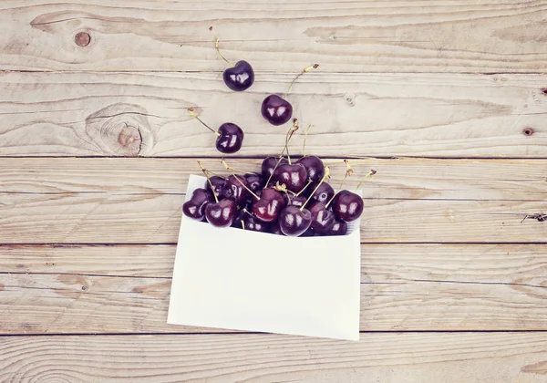 Cerezas maduras cayeron del sobre blanco — Foto de Stock