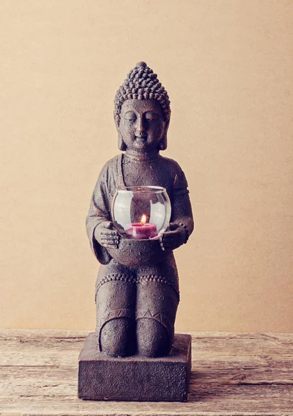 Posąg Buddy z palącej się świecy w ręce — Zdjęcie stockowe