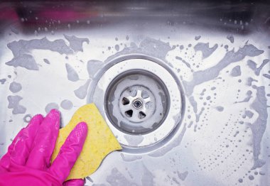 Lavabo drenaj kapatmak ve pembe lastik eldiven giyiyor el