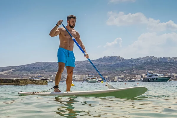 Imbarco uomo paddle in mare blu — Foto Stock