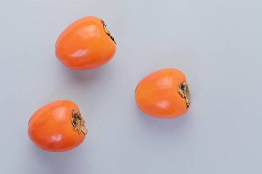 Mavi arkaplanda üç olgun hurma.