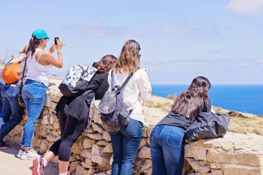 Bir grup beyaz kız öğrenci güzel manzaranın tadını çıkarıyorlar.