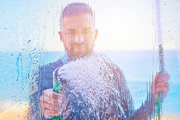 Άνθρωπος καθαρό παράθυρο με νερό από σωλήνα διάχυτο σωλήνα — Φωτογραφία Αρχείου