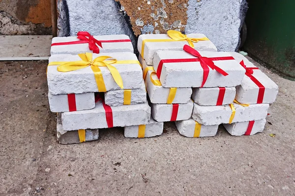 Heap av vita tegelstenar med rött och gult band som gåva till jul — Stockfoto