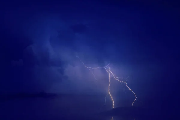 Night sky with lightning thunderstorm flash over sea