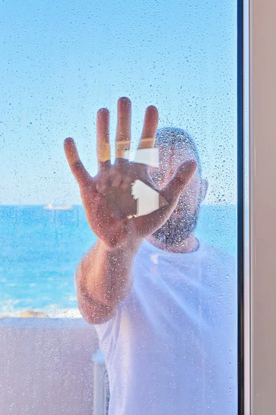 Caucasian man with raised hand through window glass — Stock Photo, Image