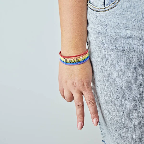 Palma femenina con signo V de los dedos en brazalete de arco iris —  Fotos de Stock