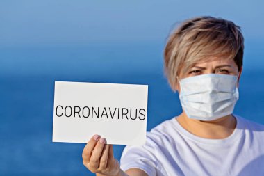 Korumalı cerrahi maskeli kadın 2019 'da Coronavirus virüsü taşıyor.