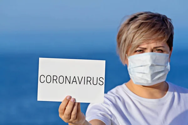 Mujer con máscara quirúrgica protectora en blanco con coronavirus de texto 2019 —  Fotos de Stock
