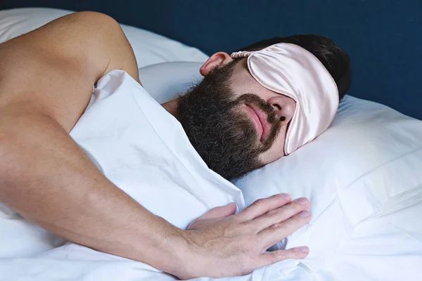 Caucasian bearded man in eyemask sleeping in bed — Stock Photo, Image