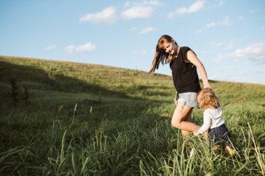 Anne ve kızı sahada yürüyor.
